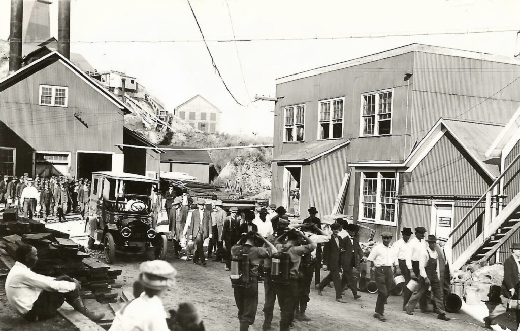 People walk out of a building in a historic photo