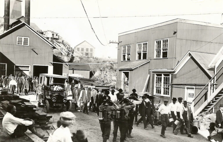People walk out of a building in a historic photo
